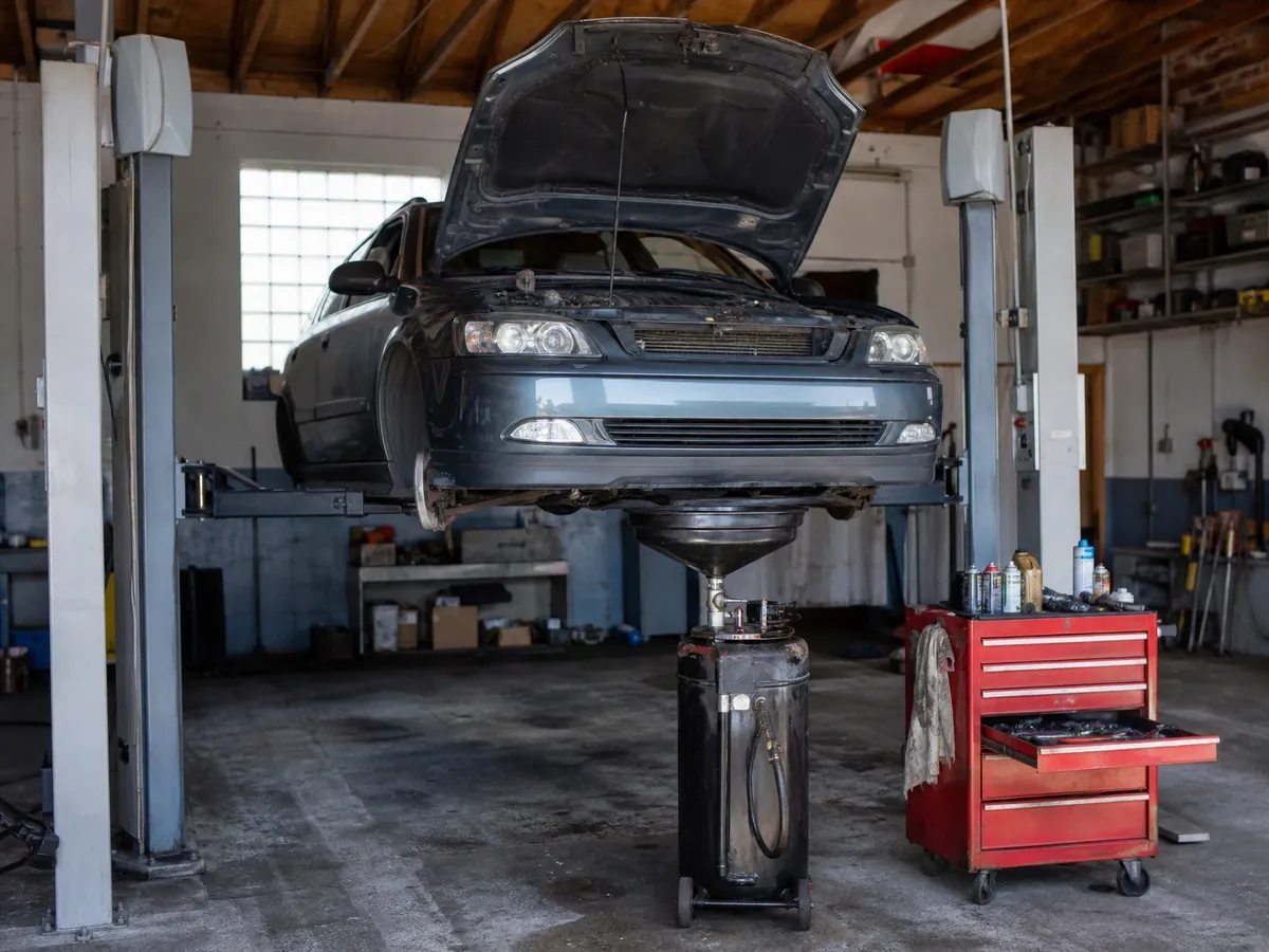 Gebrauchtwagen auf der Hebebühne, Reparaturen gehören zum Kfz-Handwerk statt zum reinen Autohandel
