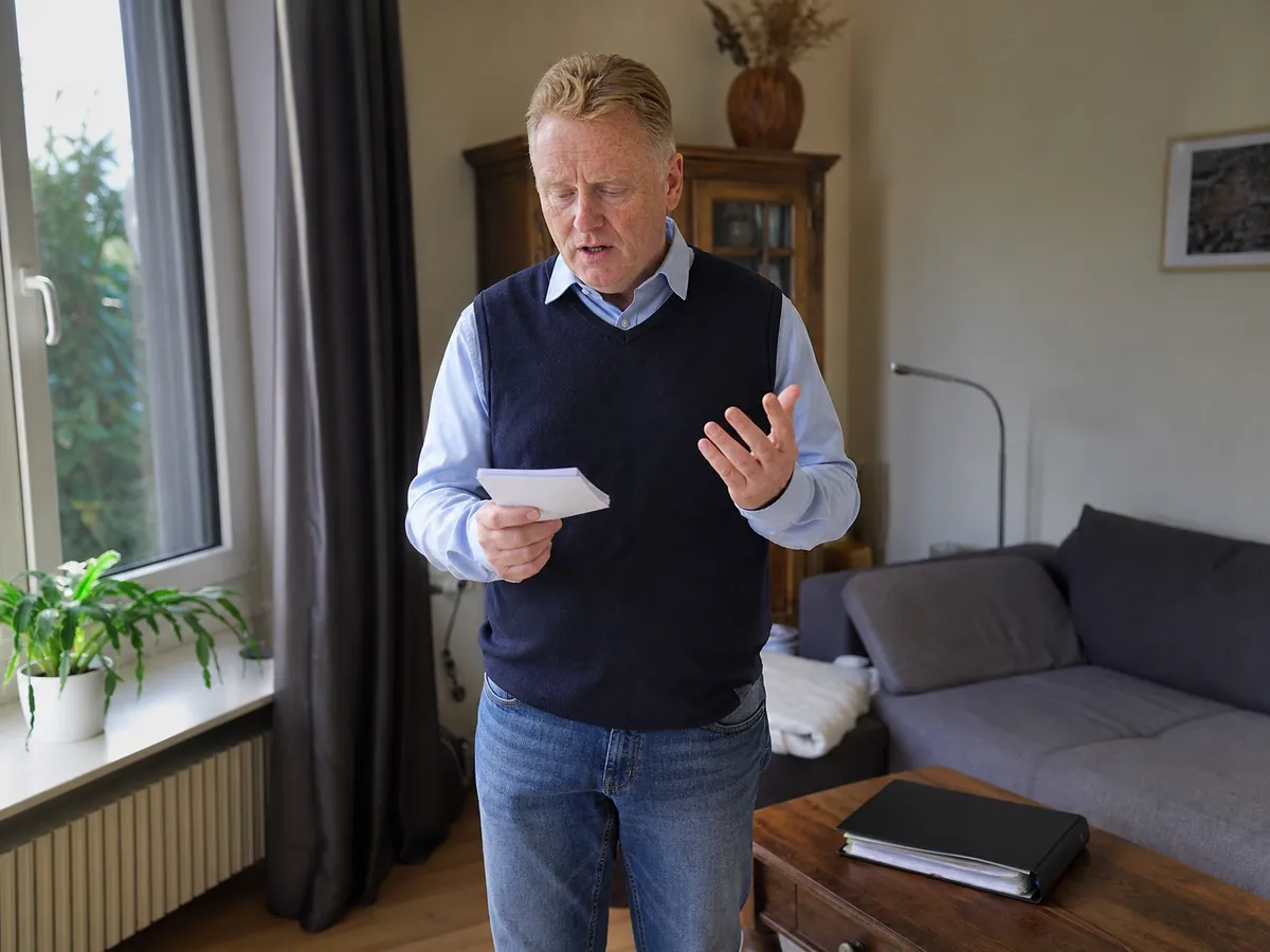 Mann probt im Wohnzimmer mit Karteikarten sein Gespräch, um den AVGS bei der Vermittlung zu beantragen