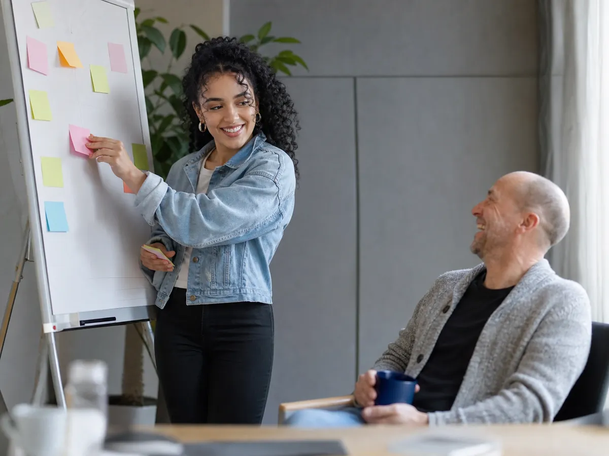 Junge Gründerin ordnet im AVGS-Gründercoaching ihre Geschäftsidee mit Haftnotizen am Flipchart