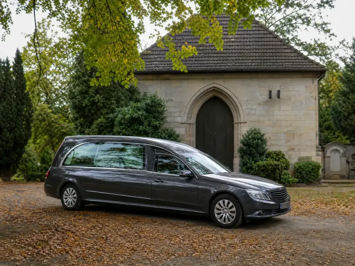 Bestattungswagen vor einer kommunalen Friedhofshalle, die Gründer anfangs mitnutzen können