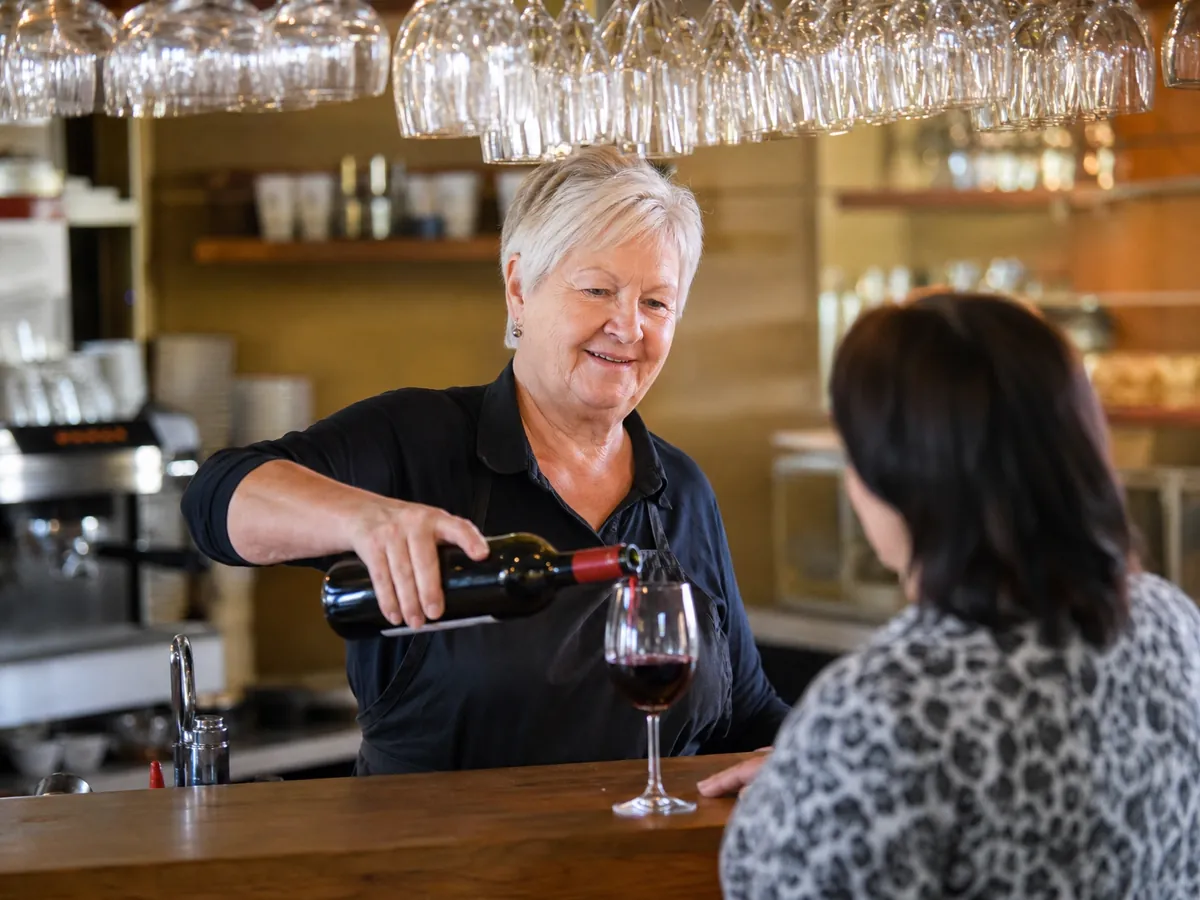 Bistro-Inhaberin schenkt Wein aus, wofür sie je nach Bundesland eine Gaststättenerlaubnis braucht