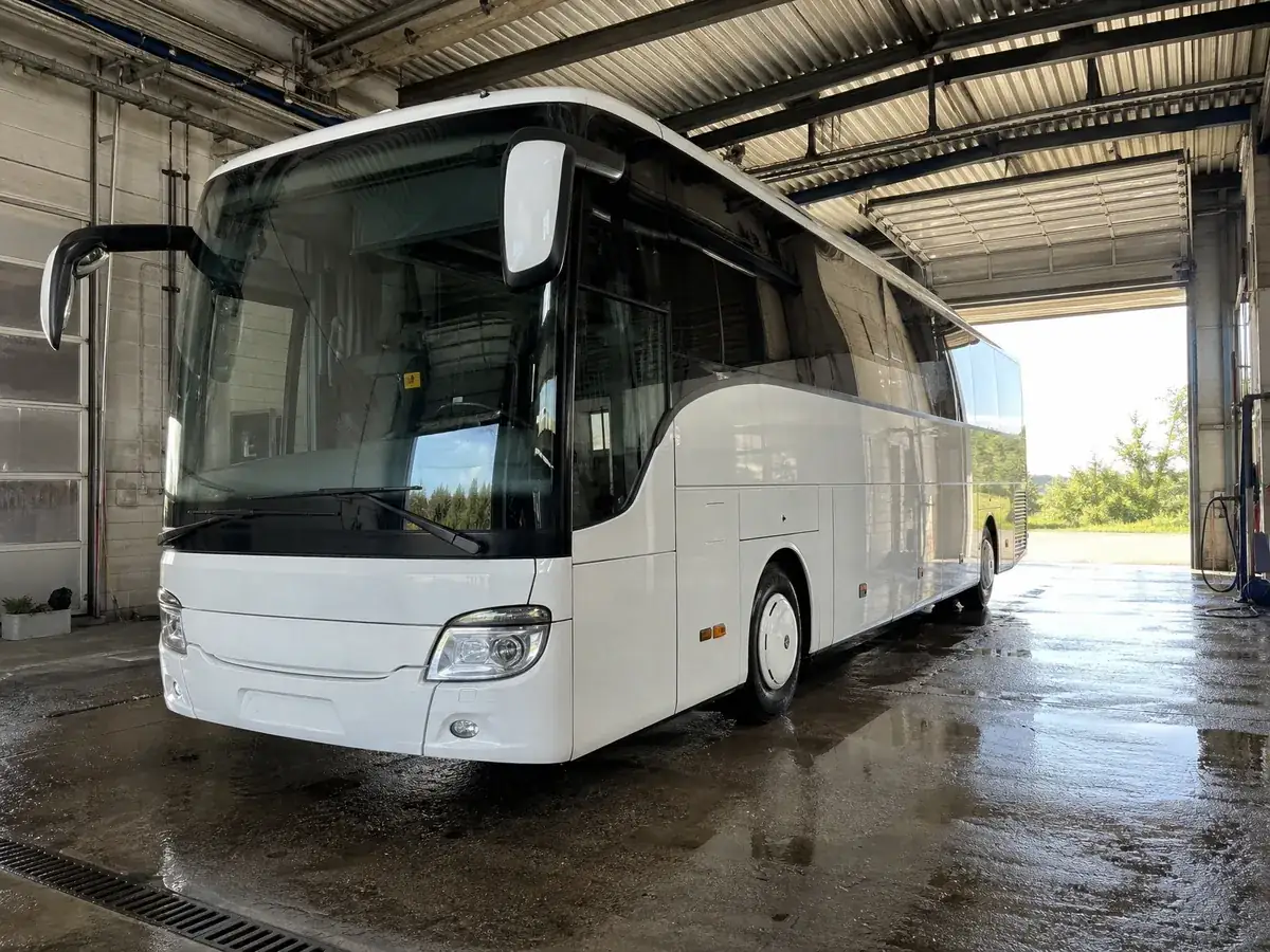 Weißer Reisebus in einer Werkstatthalle als größter Kostenposten beim Gründen eines Busunternehmens