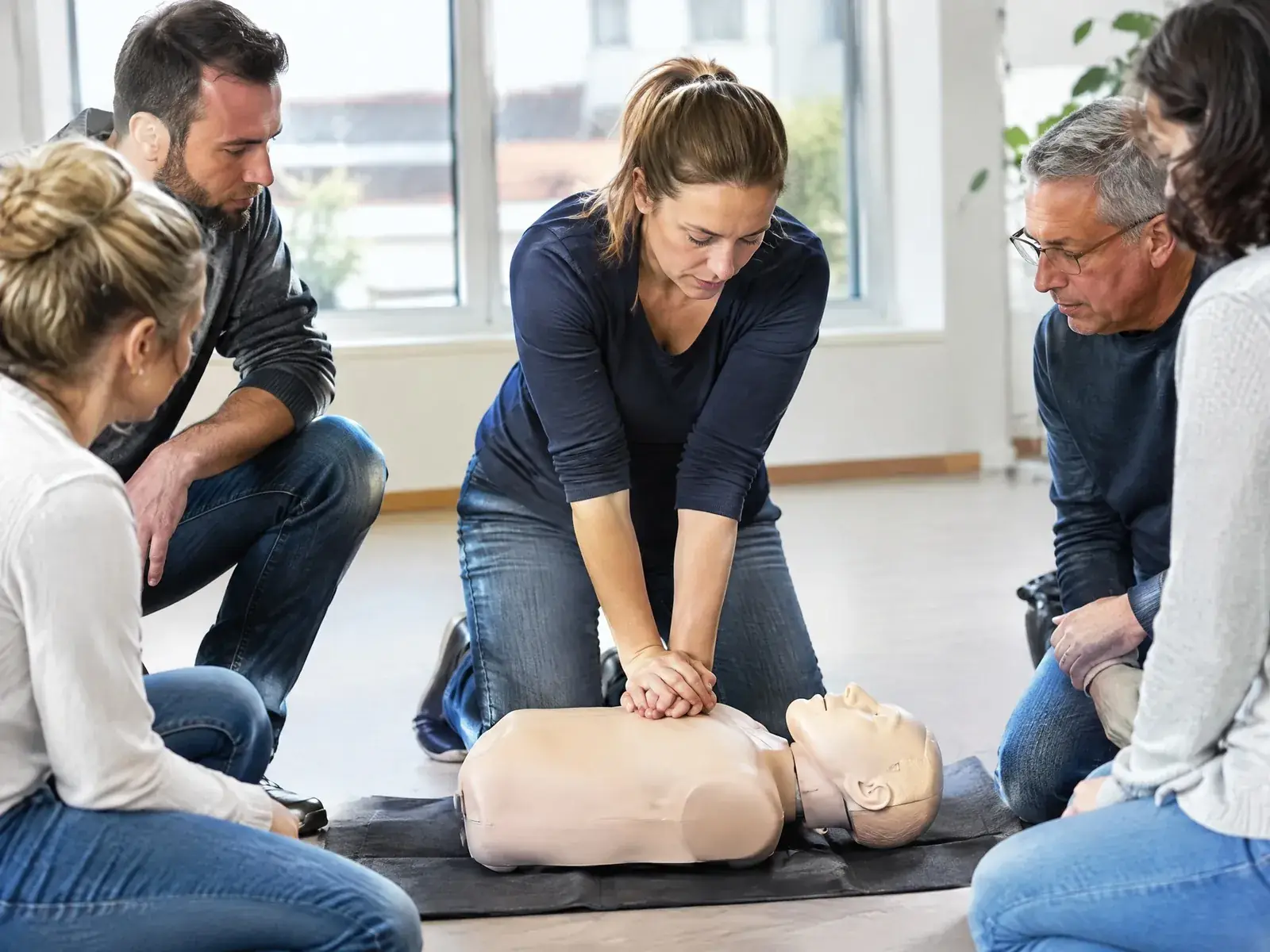 Selbstständig als Erste-Hilfe-Ausbilder: Kursteilnehmerin übt die Herzdruckmassage an der Übungspuppe