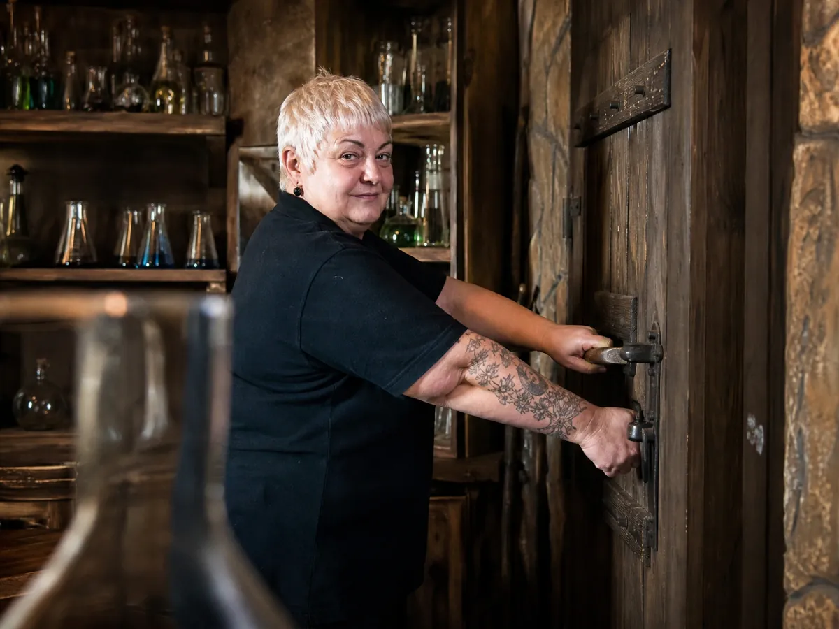 Betreiberin eines Escape Rooms testet die Notöffnung an der Tür eines als Labor gestalteten Spielraums