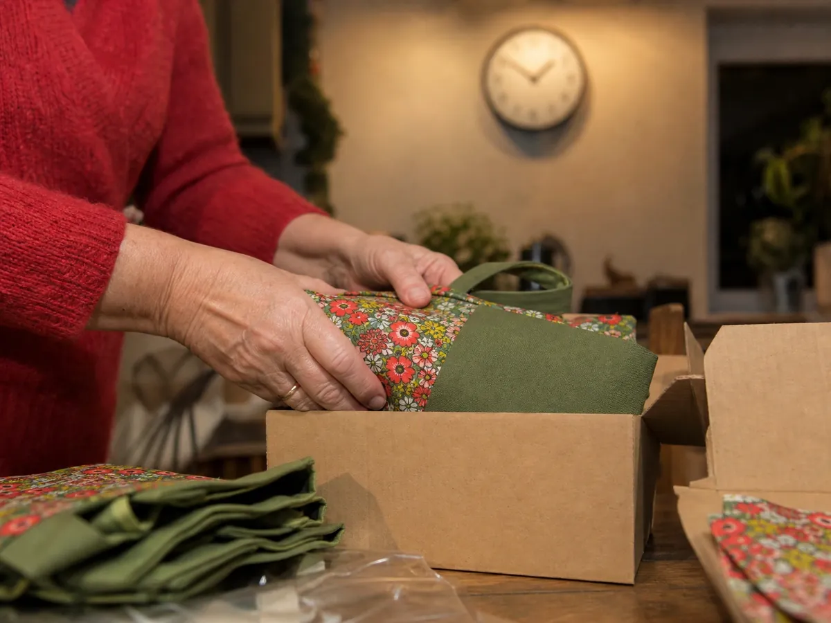 Hände packen abends genähte Taschen ein – der Zeitaufwand entscheidet über die Hauptberuflichkeit