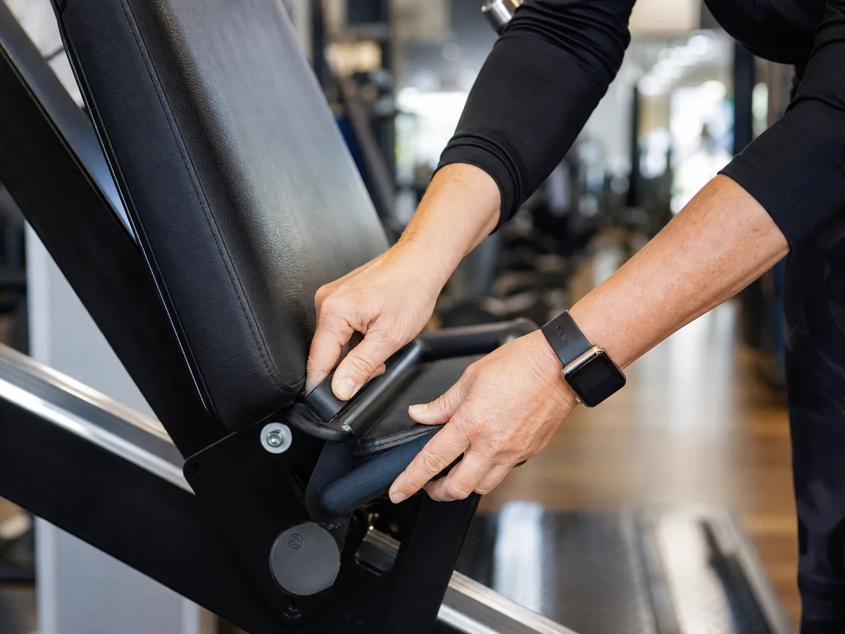 Studiobetreiberin stellt ein Trainingsgerät fachgerecht für ein neues Mitglied ein