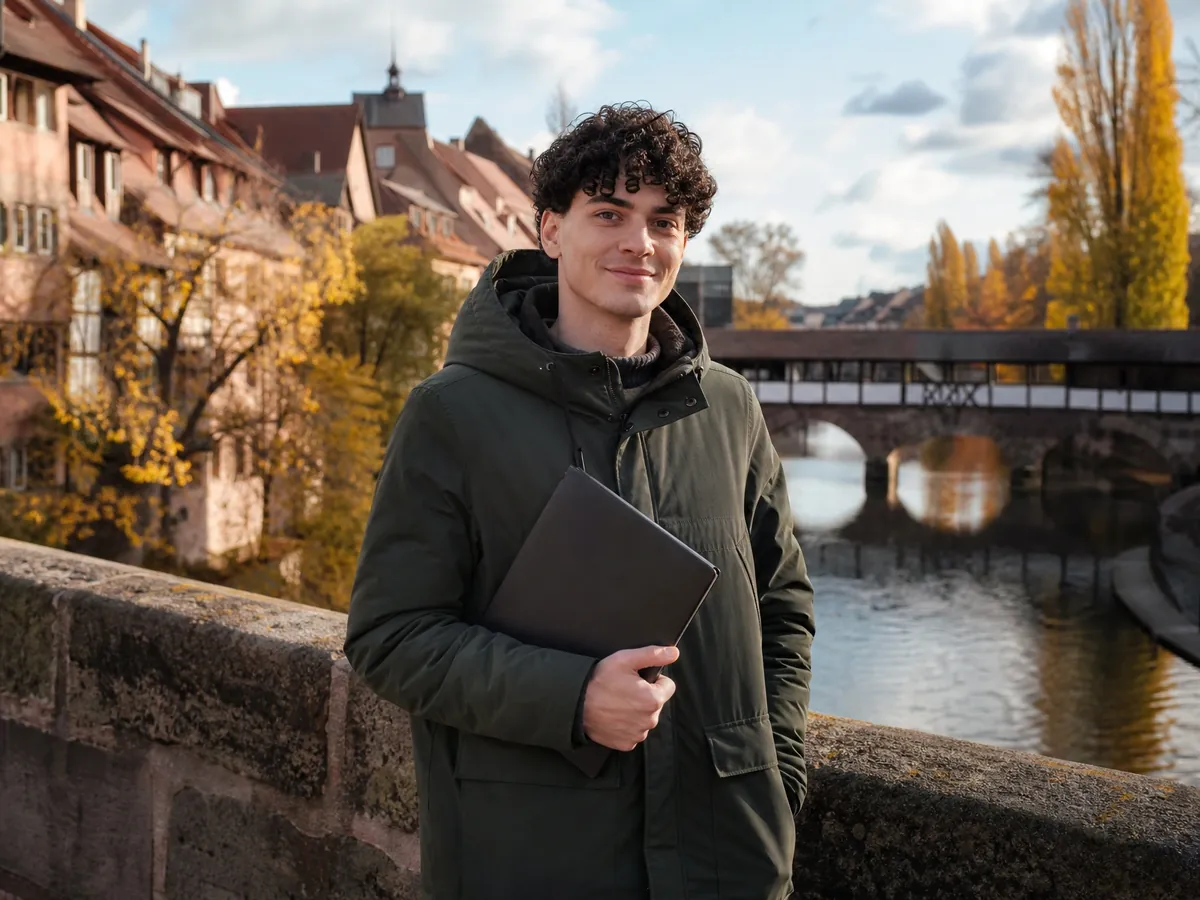 Junger Gründer auf dem Weg zur Gründungsberatung in der Nürnberger Altstadt an der Pegnitz