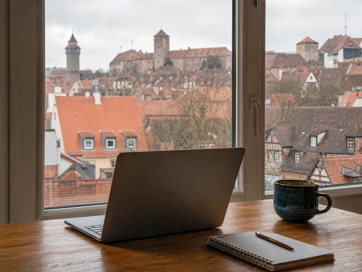 Arbeitsplatz mit Laptop und Blick auf die Nürnberger Burg für die Gründungsberatung per Video