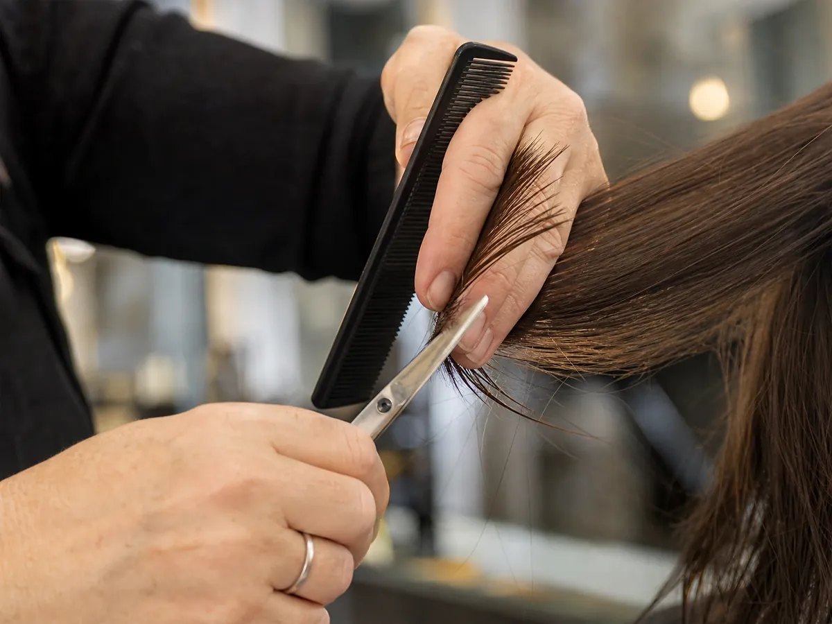 Hände einer Friseurmeisterin beim Haarschnitt im eigenen, neu gegründeten Salon im Saarland