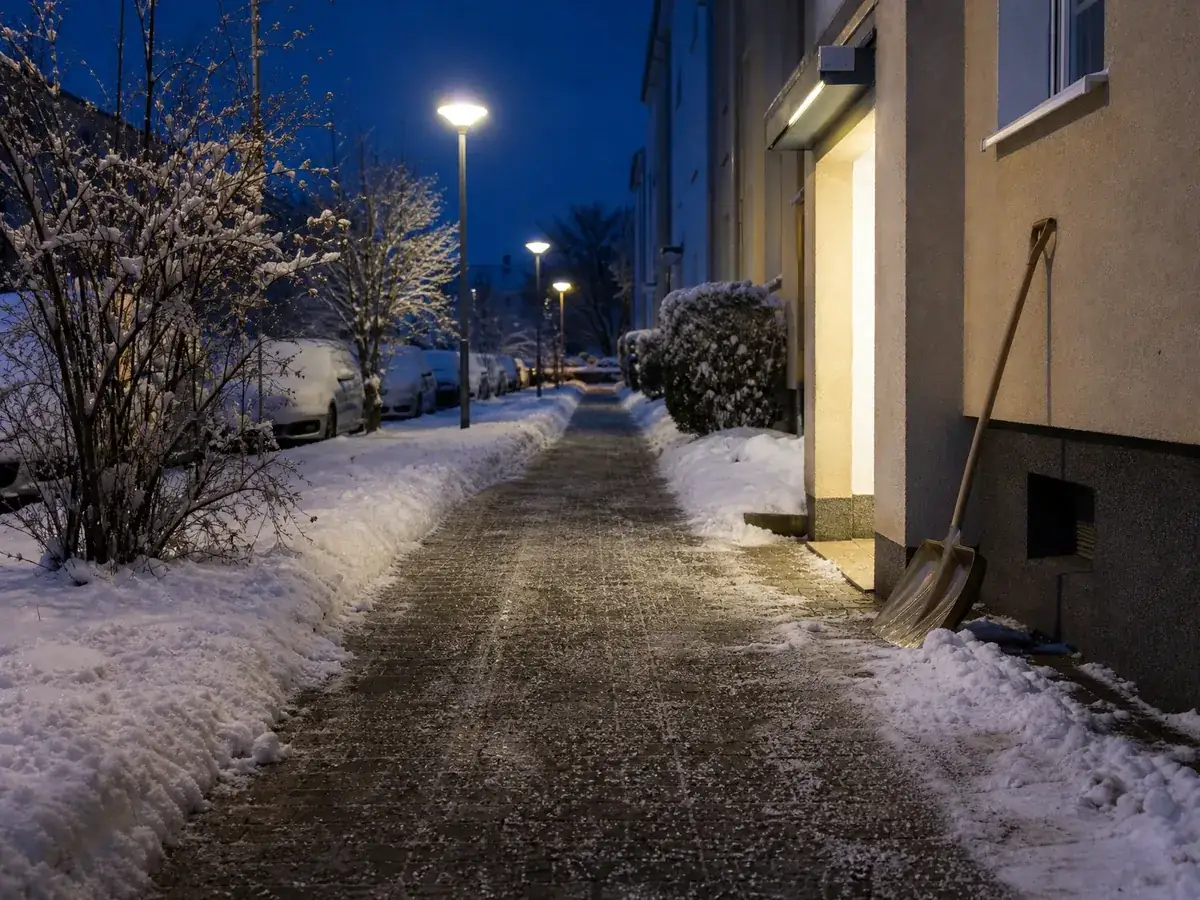 Frisch geräumter und gestreuter Gehweg am Morgen nach dem Winterdienst eines Hausmeisterservice