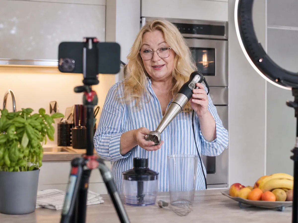 Influencerin filmt in ihrer Küche ein Video über ein Küchengerät für eine Kooperation