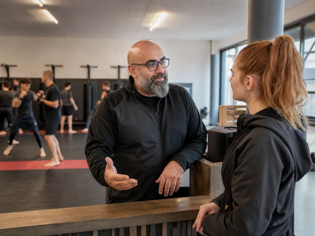 Leiter einer Kampfsportschule berät eine Interessentin zur Mitgliedschaft