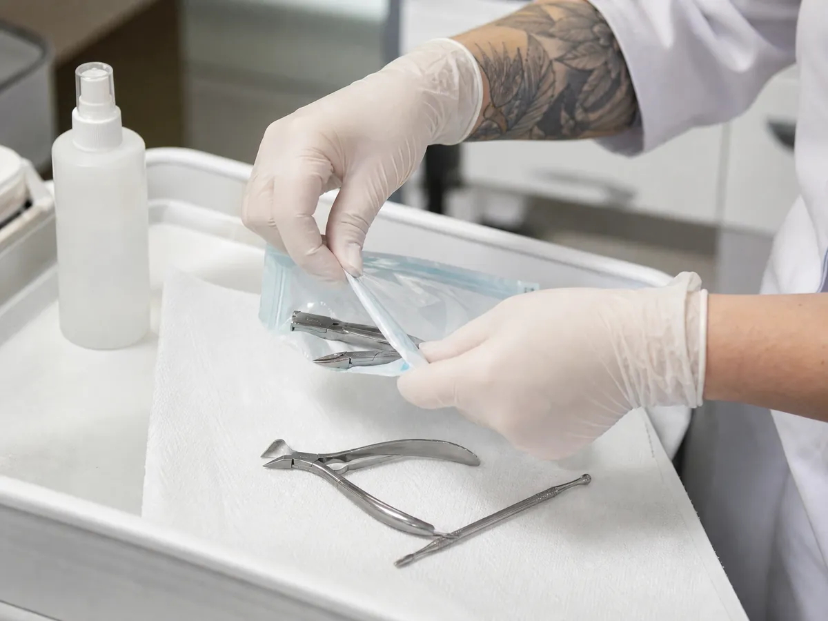 Hände in Handschuhen legen sterile Instrumente für die mobile Fußpflege bereit