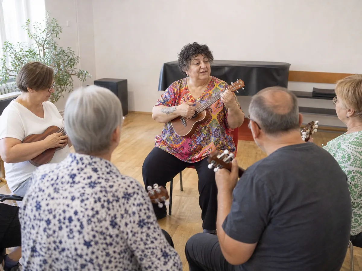 Musiklehrerin leitet in ihrer neuen Musikschule einen Ukulelekurs für erwachsene Anfänger