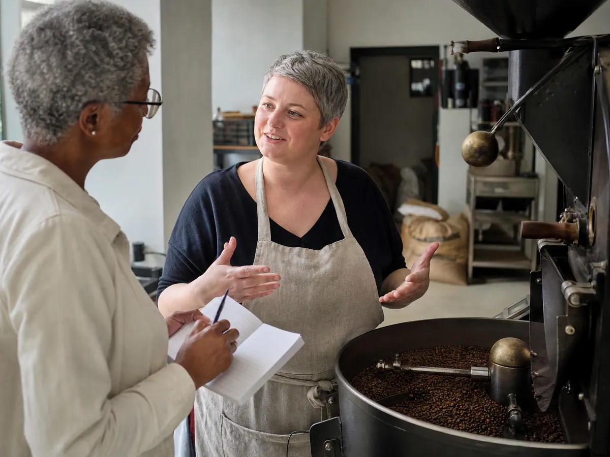 Gründerin einer Kaffeerösterei erzählt einer Lokaljournalistin am Röster ihre Geschichte