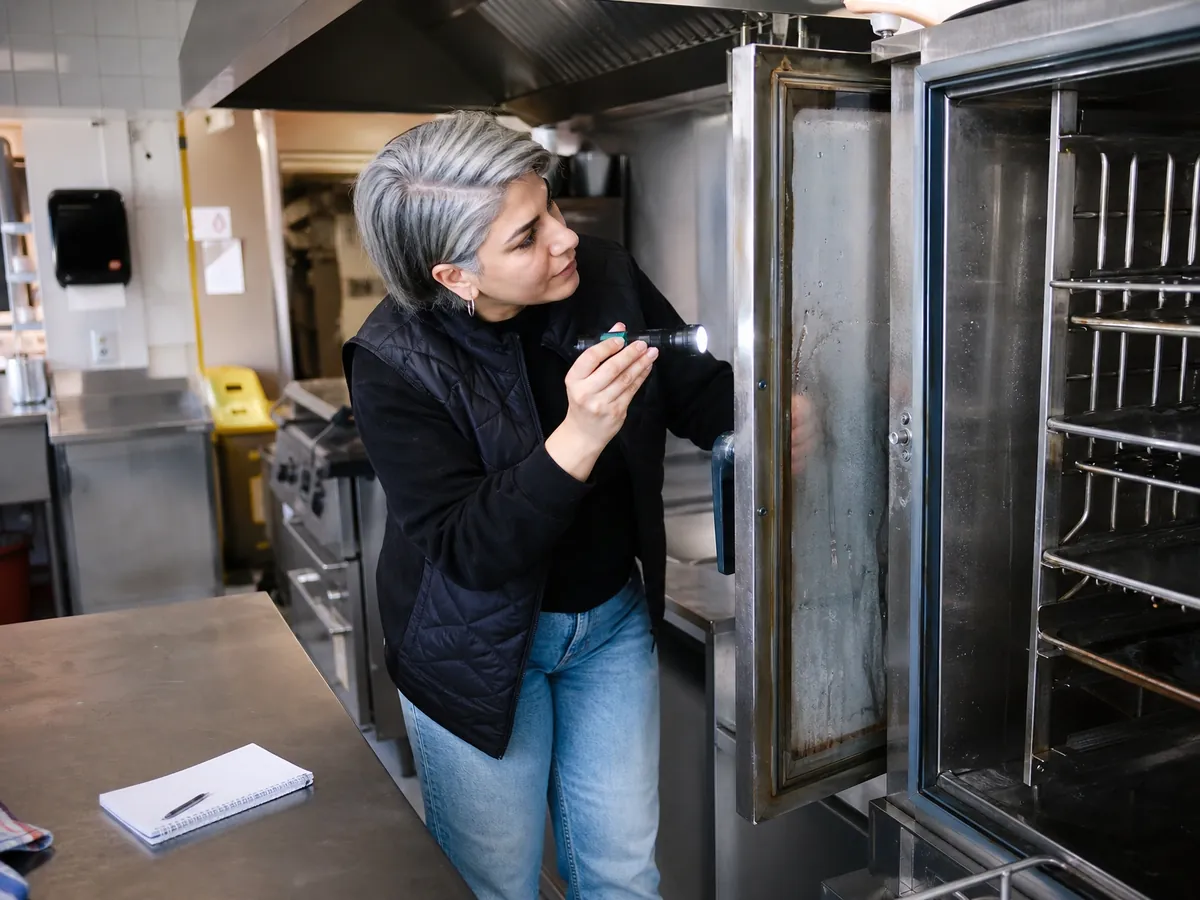 Gründerin prüft vor der Restaurantübernahme den Kombidämpfer in der gebrauchten Gastroküche