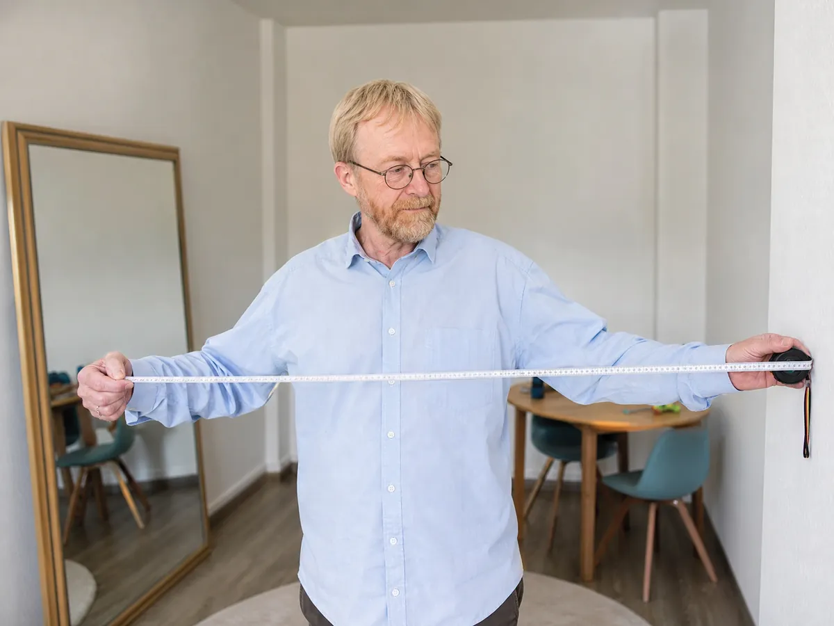 Logopäde misst seinen neuen Therapieraum aus, um die Praxisräume für die Kassenzulassung nachzuweisen