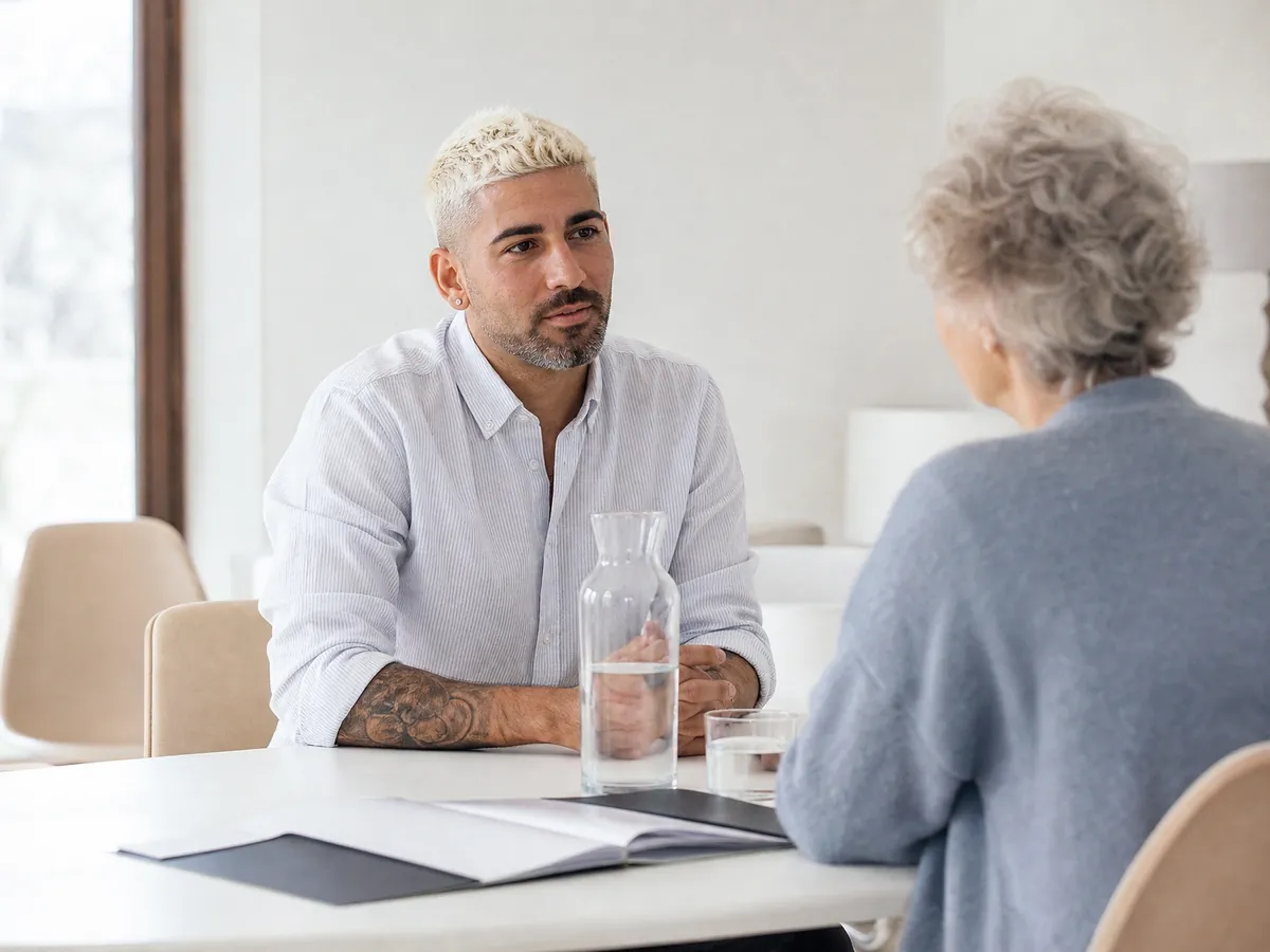 Arbeitsloser Gründer spricht in einem hellen Beratungsraum über Förderung für seine Selbstständigkeit