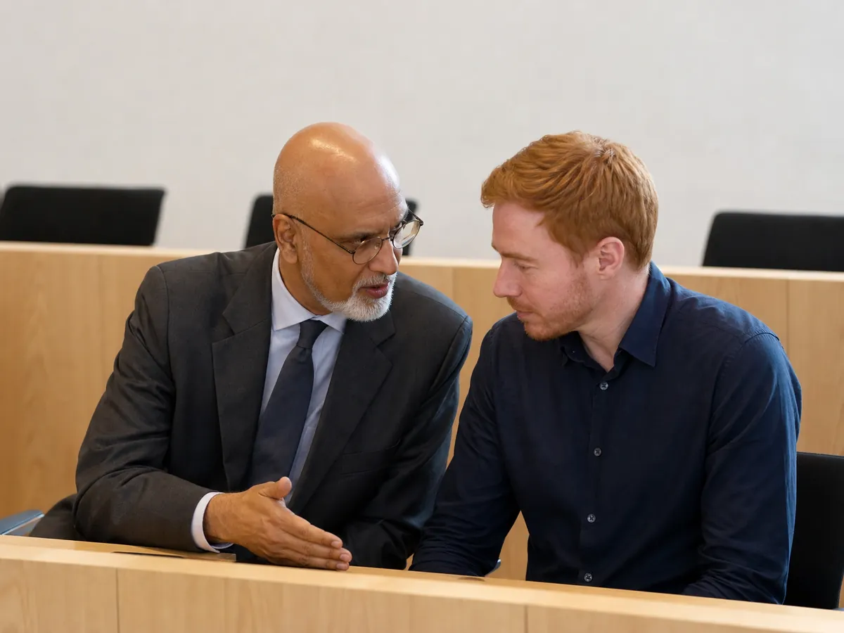 Beeidigter Dolmetscher übersetzt in einem schlichten Sitzungssaal leise für einen Beteiligten